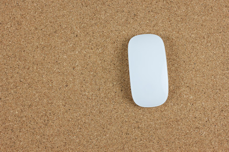Top view of computer wireless mouse on brown cork boardの写真素材