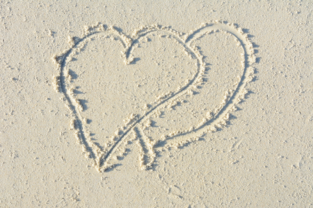 Hearts drawn on sand beachの写真素材