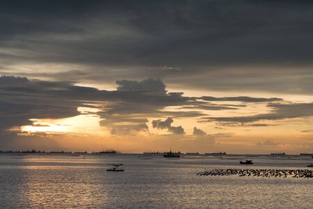 Sunset and sea view with beautiful sky in the background near industrial seaportの写真素材