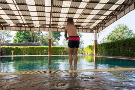 Boy jumping to swimming poolの写真素材