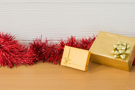 Golden gift with red ribbon on table for New Year and Christmas conceptの写真素材