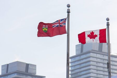 Canada and Ontario flags in front of skyscrapers in Torontoの写真素材