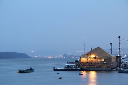 BELGRADE, SERBIA - MARCH 7, 2015: Restaurant-boat (splav in Serbian) on Danube river taken from the disctrict of Zemun in the evening. City center of Belgrade can be seen in the backgroundのeditorial素材