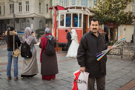 ISTANBUL, TURKEY - DECEMBER 27, 2015: Stick selfie seller looking away from people Taking wedding pictures with cameras and smartphonesのeditorial素材