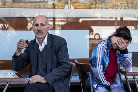 ISTANBUL, TURKEY - DECEMBER 28, 2015: Old Man drinking tea on a terrace of a coffee on the Asian side of the cityのeditorial素材