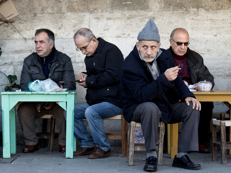 ISTANBUL, TURKEY - DECEMBER 28, 2015: Old Turkish men sitting on the terrace of a coffee near Kadikoy district, on the Asian side of the cityのeditorial素材