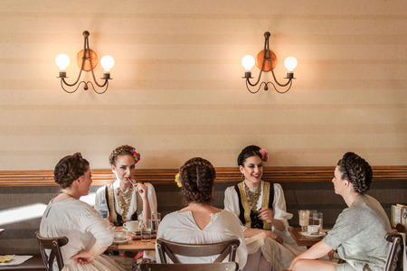 NOVI SAD, SERBIA - JUNE 11, 2017: Young women wearing a traditional Serbian costume having a drink in a local cafePicture of 5 girls having a drink in a cafe of Novi Sad, capital city of Voivodina province, Serbia, wearing a traditional Serbian outfitのeditorial素材