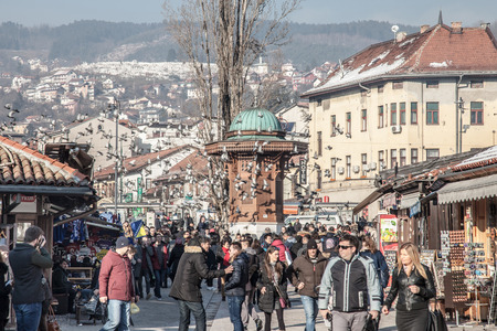 SARAJEVO, BOSNIA AND HERZEGOVINA - FEBRUARY 16, 2018: Pigeons flying over the Bascarsija square Sebilj fountain. Bascarsija is the symbol of Sarajevo, with its oriental architectureのeditorial素材