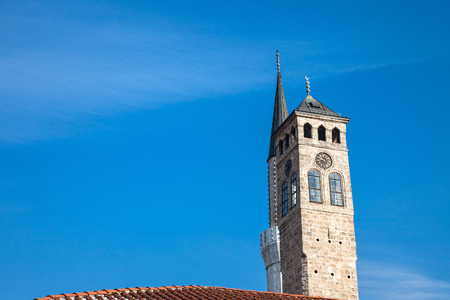 Minaret of the Gazi Husrev begova Mosque next to the clocktower of Sarajevo bazaar, in Bosnia and Herzegovinaの写真素材