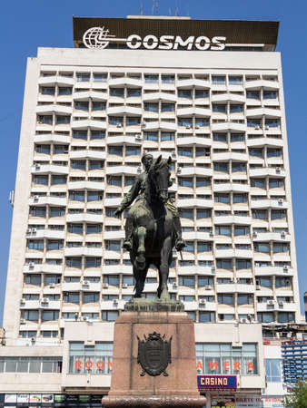CHISINAU, MOLDOVA - AUGUST 11, 2015: Statue of the Soviet Military Leader Grigori Kotovski facing the former Soviet Hotel Cosmos, one of the landmarks of the Moldovan capital cityのeditorial素材