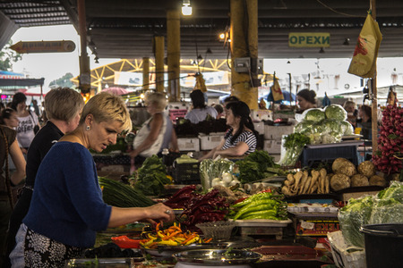 ODESSA, UKRAINE - AUGUST 13, 2015: Old woman selling fruits and vegetables, mainly peppers on the Privoz Market, Odessa, Ukraineのeditorial素材