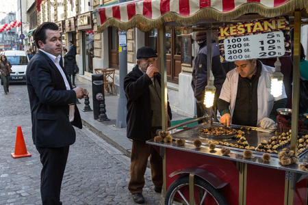ISTANBUL, TURKEY - DECEMBER 28, 2015: Old men drinking tea and chatting next to a kiosk roasting and selling chestnuts, a typical Istanbul street food for winter

Picture of a kiosk selling roasted and grilled chestnuts, in activity, surrounded by senior のeditorial素材