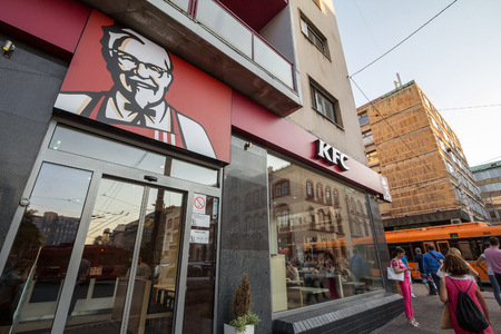BELGRADE, SERBIA - SEPTEMBER 18, 2018: Logo of KFC on their main restaurant for Belgrade. Kentucky Fried Chicken is an American fast food restaurant chain spreand worldwide

People passing by on front of a KFC sign with its iconic colonel Sanders during aのeditorial素材