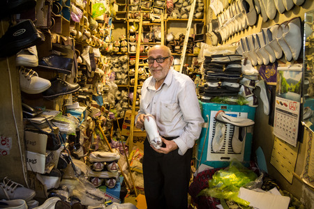 ISFAHAN, IRAN - AUGUST 8, 2015: Old Iranian shoemaker showing one of his shoes for sell in his shop in the Isfahan covered bazar market, which is one of the main landmarks of the city

Picture of a senior shoemaker of Isfahan, Iran, showing one of the shoのeditorial素材