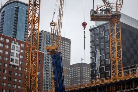 MONTREAL, CANADA - NOVEMBER 6, 2018: Cranes and building device on a construction site of a skyscraper in dowtown Montreal, surrounded by other high rise towers and condosのeditorial素材