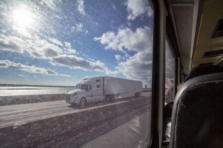 MONTREAL, CANADA - NOVEMBER 10, 2018: North American truck seen from the large window of a coach on a Quebec highway in the suburbs of Montreal, seats of the bus are visible on the rightPicture of a typical North American motorway taken from the windowsのeditorial素材