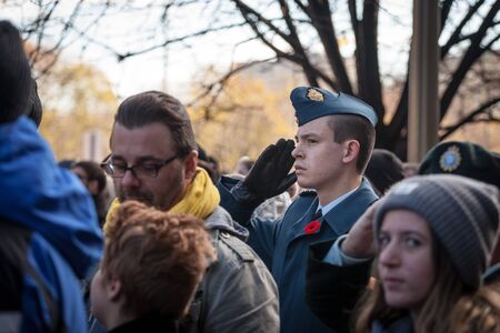 OTTAWA, CANADA - NOVEMBER 11, 2018: Soldier from Canadian Royal Air Force doing a military salute and wearing remembrance poppy, standing on ceremony for Remembrance dayPicture of a young serviceman, from the Canadian Army, Royal Air Force, standing durのeditorial素材