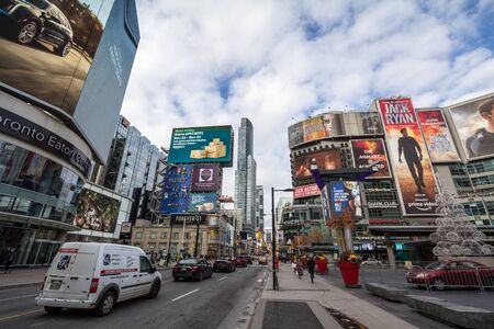TORONTO, ONTARIO - NOVEMBER 13, 2018: Yonge Dundas Square, with people and cars crossing on a sidewalk, surrounded by skyscrapers, malls, stores and shops, in a typical North American big city architecture

Perspective of Yonge Dundas square in the centerのeditorial素材
