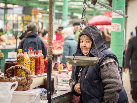 BELGRADE, SERBIA - DECEMBER 6, 2015: Senior Old woman selling fruits and vegetables on Zeleni Venac...
