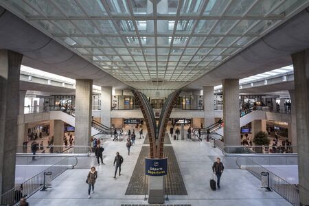 PARIS, FRANCE - NOVEMBER 2, 2018: Passengers and travellers passing by a destination board in the departures hall of terminal 2 of CDG Roissy Paris Charles de Gaulle Airport, one of the biggest hubs of EuropePicture of passengers with their suitcases paのeditorial素材