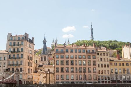 Facade of the old buildings of the vieux Lyon (Old Lyon) in France facing Colline de Fourviere Hill on the riverbank of the Rhone river during a summer afternoonの写真素材