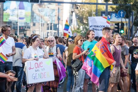 BELGRADE, SERBIA - SEPTEMBER 15, 2019:  Crowd raising gay flags  and a sign saying "love has no gender" during the Belgrade Gay Pride. The parade happened this year without trouble, under huge police watch. 

Picture of a crowd of people holding and raisiのeditorial素材