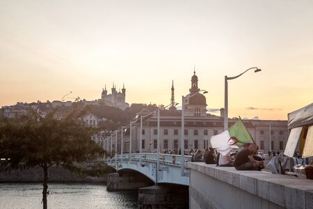 LYON, FRANCE - JULY 14, 2019: Man waiving an Algerian flag in the center of Lyon, with landmarks such as the Basilique Notre Dame de Fourviere Church, during a football match committing Algeria

Picture of the city center of Lyon, with monuments like the のeditorial素材
