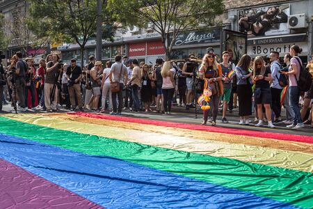 BELGRADE, SERBIA - SEPTEMBER 18, 2016:  Crowd of protestors standing behind a giant rainbow gay flag...