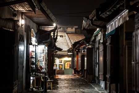 SARAJEVO, BOSNIA - APRIL 15, 2017: Narrow street of Bascarsija district of Sarajevo at night, with metal copper crafts being produced. Bascarsija is symbol of Sarajevo, with its oriental architecturePicture of one of Bascarsija's streets during a dark eのeditorial素材