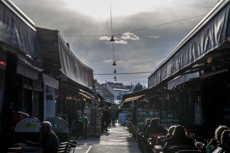VIENNA, AUSTRIA - NOVEMBER 6, 2019: Main Alley of the Wien naschmarkt, with terraces of cafes and restaurants full of locals and tourists. It is one of the most iconic markets of Vienna.

Picture of the naschmarkt of Vienna, Austria, with people sitting dのeditorial素材