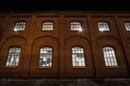 Facade of a vintage old red brick warehouse, used from an Industrial Revolution Era facotry plant,...