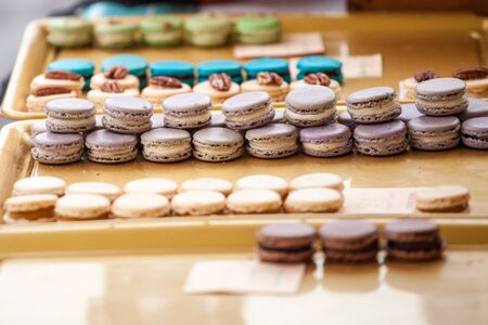 Lavander flavored purple macarons on display in a French pastry shop among other macaroons.