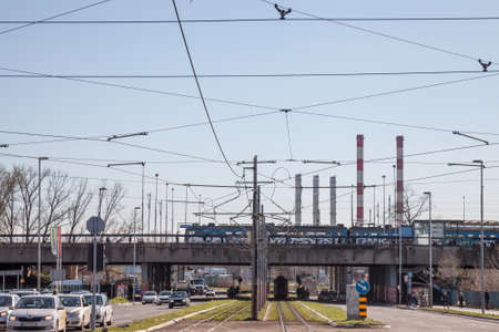 BELGRADE, SERBIA - APRIL 2, 2018: Train station of Novi Beograd, a suburban multimodal public transportation hub, with a tram stop and buses passing by near railways.Picture of a train entering the suburban station of Novi Beograd, in Belgrade, Serbia, のeditorial素材