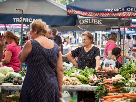 OSIJEK, CROATIA - AUGUST 26, 2017: Traditional scene of the Osijek green market with old women selling fruits and vegetables. Osijek is the center of Slavonija, the most agricultural zone of Croatia.Picture of Osijek Green market. Osijek is the capital のeditorial素材