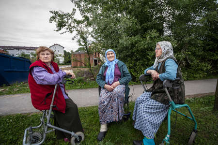 BRCKO, BOSNIA, MAY 6, 2017: Senior Bosniak Women, wearing the traditional muslim scarf, sitting and discussing among friends in the streets of the Bosnian city of Brcko.Picture of three retired women, Bosniak, in Brcko, Bosnia and Herzegovina, sitting aのeditorial素材