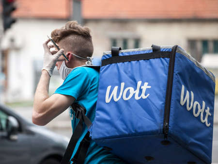 BELGRADE, SERBIA - MAY 5, 2020: Wolt delivery man wearing a face mask protective respirator in...