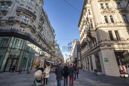 VIENNA, AUSTRIA - NOVEMBER 6, 2019: Panorama of Karntner street with people shopping in stores around. Karntnerstrasse is the main pedestrian street of the center of Vienna.Picture of people rushing on kartnerstrasse street in Vienna, Austria. Karntner のeditorial素材