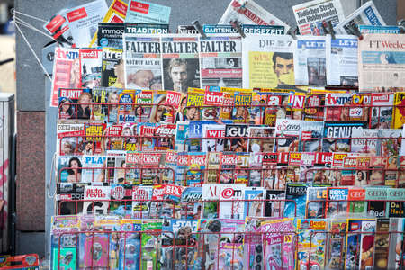 VIENNA, AUSTRIA - NOVEMBER 6, 2019: Magazine rack shelves filled with journals and newspaper in German, from an Austrian press reseller in downtown Vienna.Picture of a press kiosk in the center of Vienna, Austria, filled with newspapers aligned in a magのeditorial素材