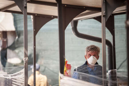 BELGRADE, SERBIA - APRIL 23, 2020: Old man, a merchant on Belgrade green farmers market, selling vegetables & fruits wearing face mask protective equipment.のeditorial素材