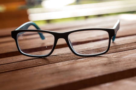 Dirty eyeglasses, presciption glasses, on display, with several spots, marks and fingerprints...