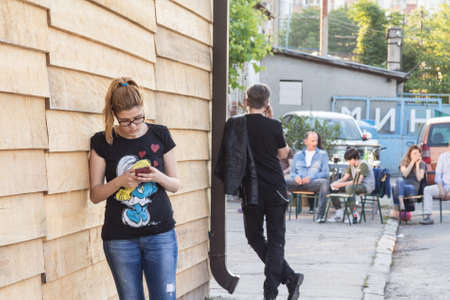 BELGRADE, SERBIA - MAY 21, 2016: Two youngsters, female and male, calling using their smartphones,...