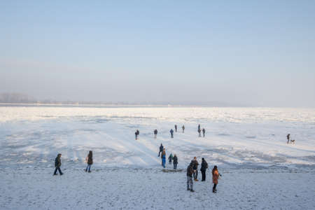 BELGRADE, SERBIA - JANUARY 21, 2017: Group of people, crowd, walking on the Frozen Danube during the 2017 winter, in Zemun. This winter was particularly harsh, paralyzing activity on the Danube.のeditorial素材