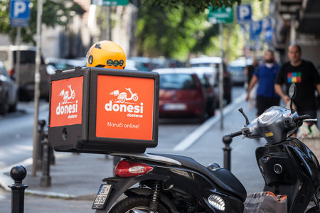 BELGRADE, SERBIA - AUGUST 22, 2020: Donesi Dostava logo on a scooter on a delivery guy in Belgrade....