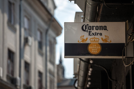 BELGRADE, SERBIA - AUGUST 9, 2020: Cerveza Corona logo in front of a local retailer bar in Belgrade. Cerveza Corona is a Mexican brand of light lager beer, one of the biggest mexico exporter of beer. Picture of a sign with the logo of Corona Beer in frontのeditorial素材