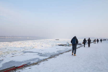 BELGRADE, SERBIA - JANUARY 21, 2017: Group of people, crowd, walking on the Frozen Danube during the 2017 winter, in Zemun. This winter was particularly harsh, paralyzing activity on the Danube.のeditorial素材