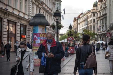 BELGRADE, SERBIA - OCTOBER 17, 2020: Middle aged man walking in the Kneza Mihailova street of Belgrade wearing face mask protective equipment.のeditorial素材