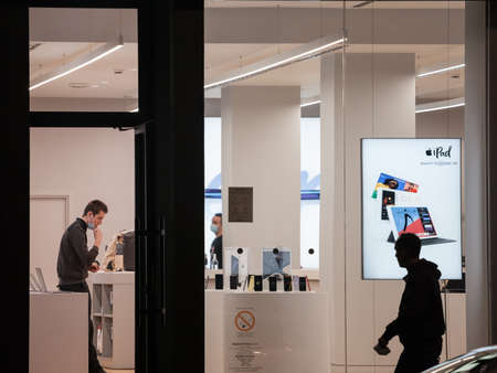 BELGRADE, SERBIA - OCTOBER 30, 2020: male worker of a Apple products retailer, Istyle, wearing a respiratory face mask in Belgrade.のeditorial素材