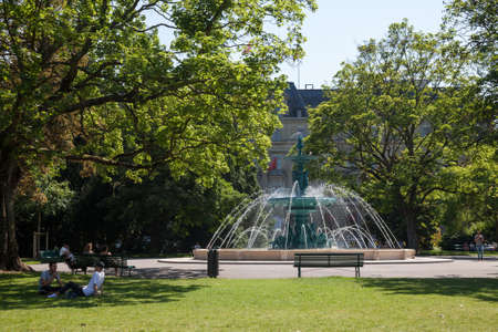 GENEVA, SWITZERLAND - JUNE 19, 2017: People relaxing on the lawns of the Jardin Anglais in geneva, in front of the fountain of the four seasons foutain, a major landmark.のeditorial素材