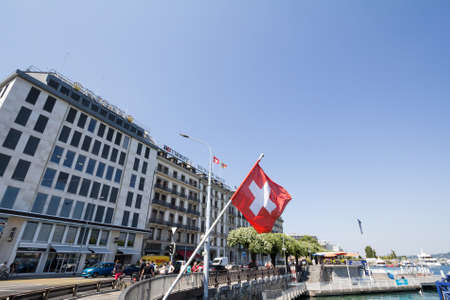GENEVA, SWITZERLAND - JUNE 19, 2017: Flag of the flag of Switerland in the city center of Geneva, on the Leman lake, in front of the Quai du Mont Blanc street quay.のeditorial素材