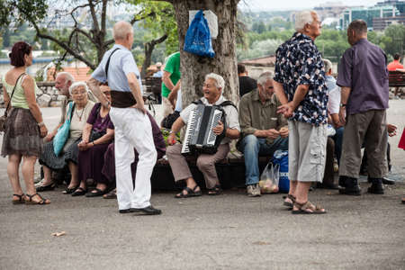 BELGRADE, SERBIA - JULY 2, 2017: Serbian old people having fun and laughing playing accordion in the main park of Belgrade, Kalemegdan fortress, in summer.のeditorial素材
